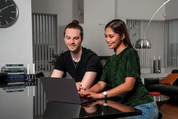 Young couple looking at a computer at home.